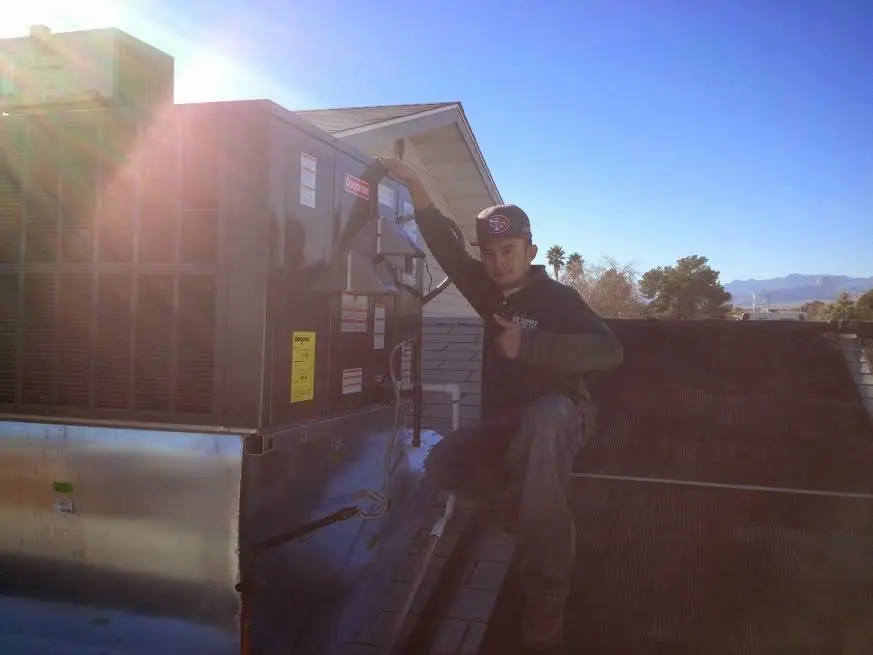 HVAC technician performing AC Tune-Up on a rooftop unit in Umatilla